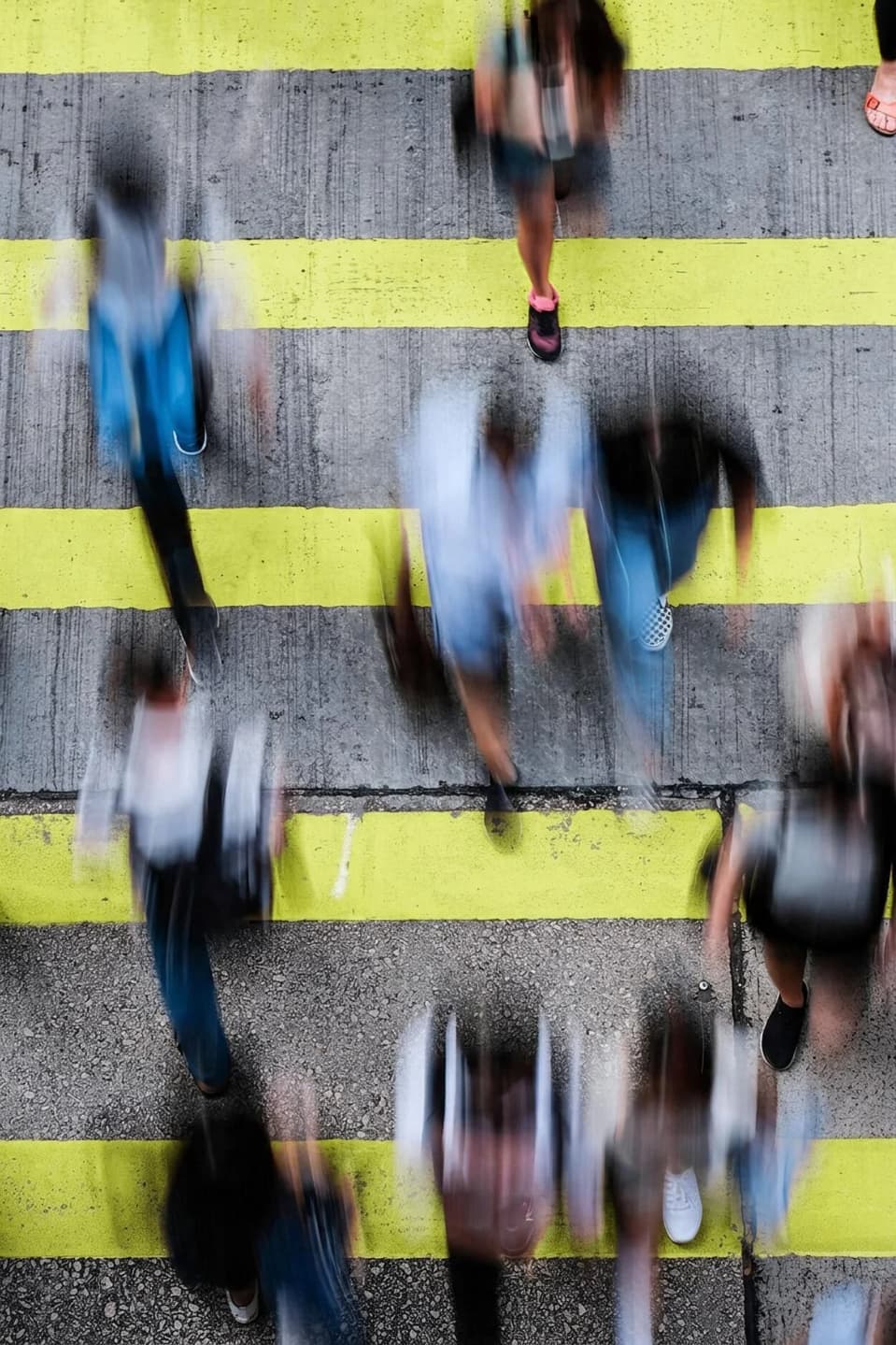 Aerial view of a crosswalk with a blurred crowd and one person highlighted